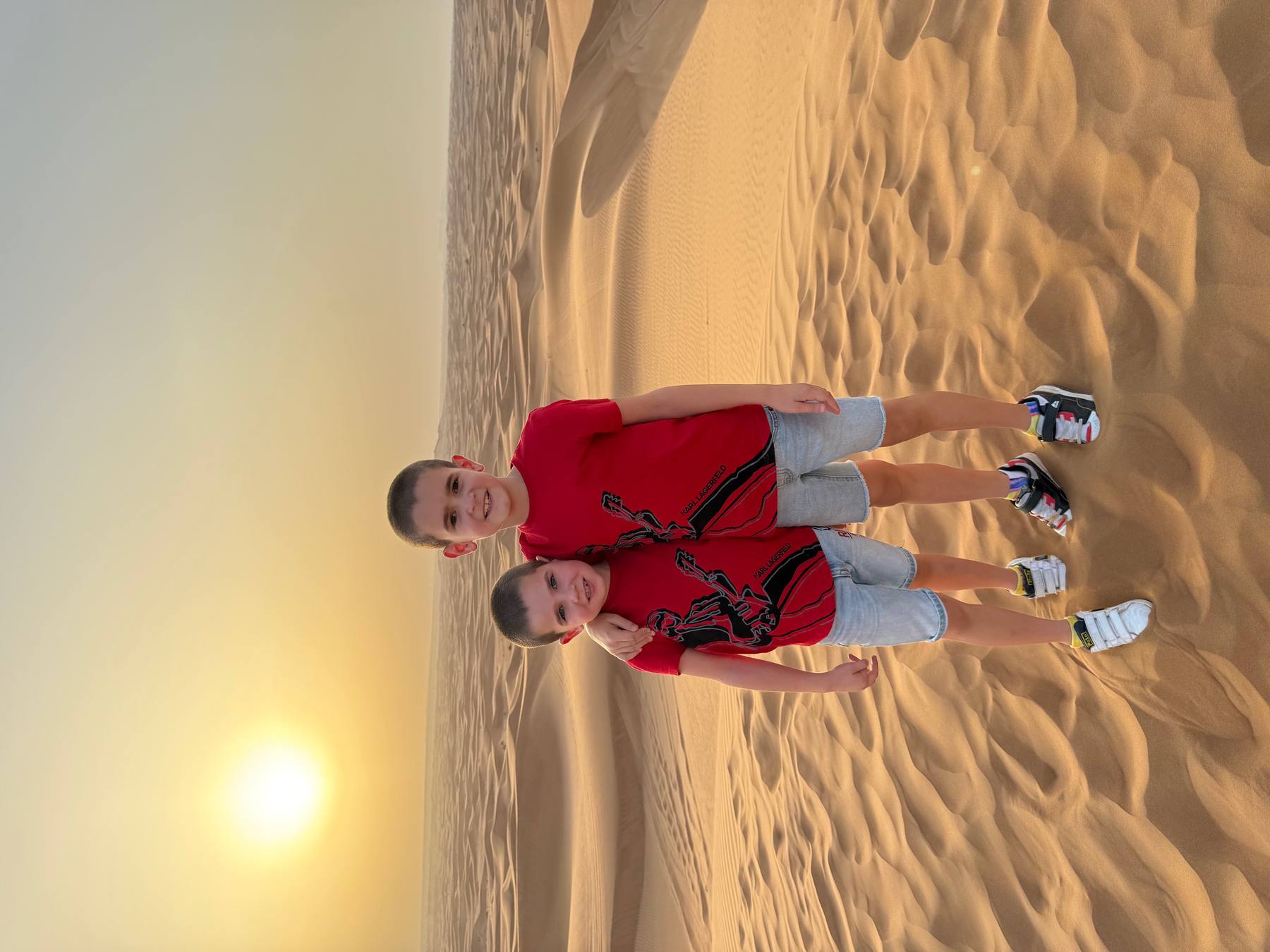 Aaron and Nathan Lederer, founders of The Cake Coin Bros, in the Dubai desert at sunset